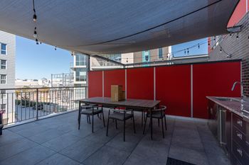 A patio with a table and chairs under a white canopy.